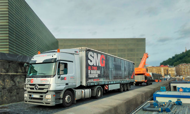 imagen de camión de SMG aparcado en la noche con luces