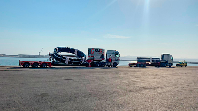 dos camiones de SMG cargados y coche de guía en el puerto 